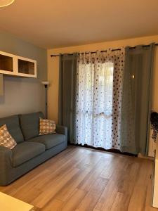 Casa Tea في لوكّا: غرفة معيشة مع أريكة ونافذة