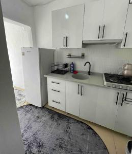 a kitchen with white cabinets and a sink at Denize 2 km Manzaralı ve Ferah 2+0 Daire (Konum Eşelek Köyü) in Gokceada Town