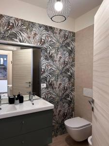 ein Badezimmer mit einem Waschbecken, einem WC und einem Spiegel in der Unterkunft Casa Tea in Lucca