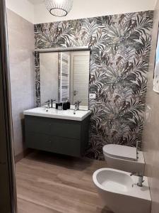ein Badezimmer mit einem Waschbecken, einem WC und einem Spiegel in der Unterkunft Casa Tea in Lucca