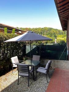 einen Tisch und Stühle mit Sonnenschirm auf einer Terrasse in der Unterkunft Casa Tea in Lucca