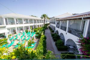 a view of the courtyard of a hotel with lounge chairs at Sofia's Hotel in Kalamaki