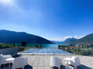 a tennis court with white chairs and a view of a lake at Vela di Soleville camere con e senza vista lago con ristorante & pizzeria in Sale Marasino