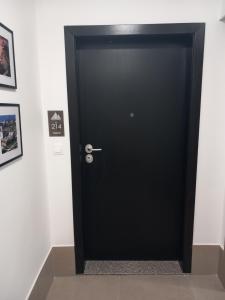 a black door in a room with pictures on the wall at Zeirene in Skopje