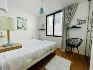 ein Schlafzimmer mit einem Bett, einem Stuhl und einem Fenster in der Unterkunft Appartement Arcachon, 3 pièces, 6 personnes - FR-1-433-108 in Arcachon