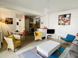 ein Wohnzimmer mit einem Sofa, Stühlen und einem Tisch in der Unterkunft Appartement Arcachon, 3 pièces, 6 personnes - FR-1-433-108 in Arcachon