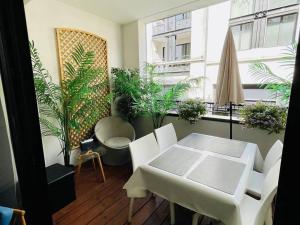 einen Tisch und Stühle in einem Zimmer mit Pflanzen in der Unterkunft Appartement Arcachon, 3 pièces, 6 personnes - FR-1-433-108 in Arcachon