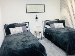 two beds sitting next to each other in a bedroom at Paradise St Apartment Middle Floor 1 flight of stairs 3 bed 1 bathroom in Rhyl