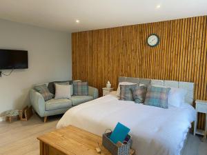a bedroom with a bed and a couch and a clock at Sandy Top in Saint Abbs