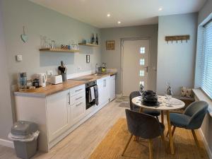a kitchen with a table and a table and chairs at Sandy Top in Saint Abbs