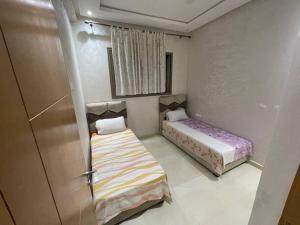 a small room with two beds and a door at Bahia beach . Plage dahomey in Bouznika