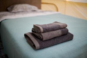 a pile of towels sitting on top of a bed at glamping Shangri la 