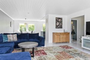 a living room with a blue couch and a table at Villa nära Varberg och Ullared in Varberg