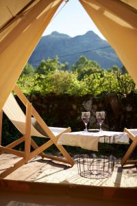 a table with two wine glasses on top of a tent at glamping Shangri la 