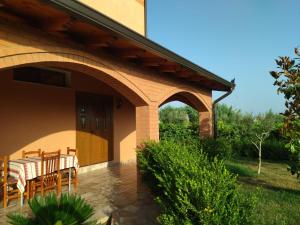 una casa con patio con mesa y sillas en The Garden Guest House, en Divjakë