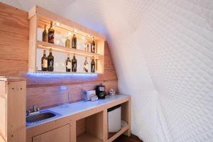 baño con lavabo y una estantería de botellas de vino en Casa Domo Glamping by BajaHomeStays, en Francisco Zarco