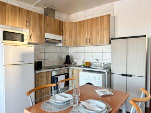 a kitchen with a wooden table and a white refrigerator at Casa da Lena in Fuzeta