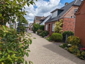 a cobblestone street in a town with houses at Kaeptn Hinnerk in Wyk auf Föhr