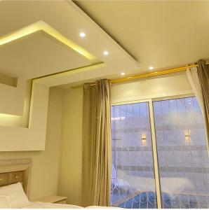 a bedroom with a large mirror and a window at Lantana Chalets in Al Liqāʼ