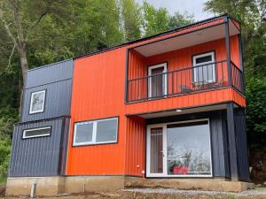 瓦爾迪維亞的住宿－Casa Nueva en Parcela de Agrado，橙色和黑色的房子设有阳台