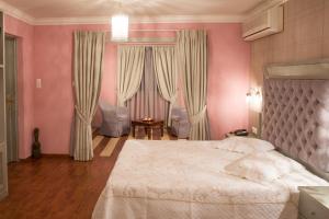 a bedroom with a large bed with pink walls at Delphi Art Hotel by Prima Hotels in Athens