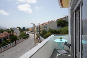 a balcony with a table and a view of a street at Vivenda Godinho in Nazaré