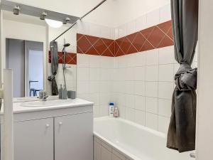 a bathroom with a sink and a tub and a mirror at Gare Annemasse Proche GENEVE in Annemasse