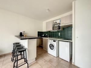 a kitchen with white cabinets and a washer and dryer at Gare Annemasse Proche GENEVE in Annemasse