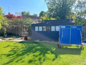 a blue shed sitting in a yard next to a house at Self contained annex with full kitchen in Witney