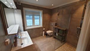 a bathroom with a shower and a sink and a toilet at Moen Booking in Åndalsnes