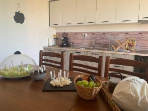 une cuisine avec une table en bois et des paniers de pommes dans l'établissement Villa Apollonia Guest House, à Fier