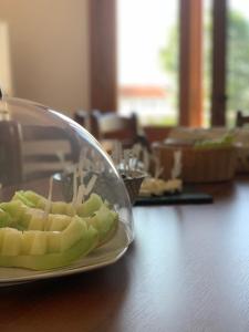 a plate of fruit on a wooden table at Villa Apollonia Guest House in Fier