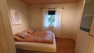 a small bedroom with a bed and a window at Moen Booking in Åndalsnes