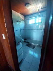 a bathroom with a glass shower with a toilet at Namorada Brava Guest House in Búzios