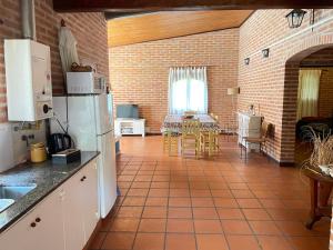 a kitchen with a refrigerator and a table with chairs at Pintoresca casa con pileta in Yala +9 photos