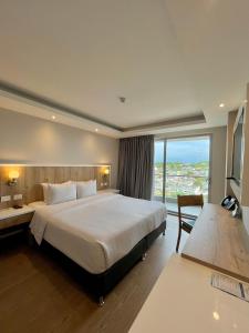 um quarto com uma cama grande e uma janela grande em Wyndham Garden Cartagena em Cartagena das Índias