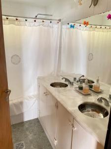 ein weißes Bad mit 2 Waschbecken und einer Dusche in der Unterkunft Pintoresca casa con pileta in Yala