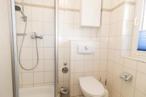ein Bad mit einer Dusche und einem WC in der Unterkunft Cuxhaven Fewo Döse Oasis-04 in Döse