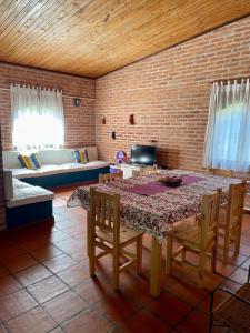 Habitación con mesa, sillas y pared de ladrillo. en Pintoresca casa con pileta in 