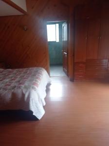 CuracavíにあるCabaña con piscina en Curacavíのベッドルーム1室(ベッド1台付)、窓付きのドアが備わります。