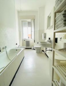a white bathroom with a tub and a toilet at Vera House - Big solution in Brescia