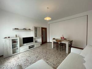 a white living room with a table and a television at Vera House - Big solution in Brescia