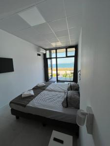 a bedroom with a bed with a view of the ocean at Aliara Dilara Beach Apartments in Pomorie