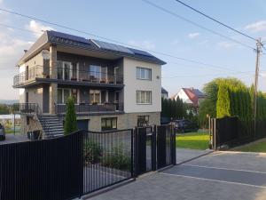 una casa con una valla negra delante de ella en Apartament Górski R.M., en Raba Wyżna