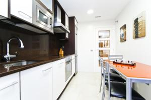 een keuken met witte kasten en een oranje aanrecht bij J Tramuntana Planet Costa Dorada in Salou