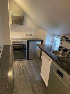 a small kitchen with a sink and a stove at 1 bed flat at Drum Street in Edinburgh