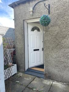 una puerta blanca con una maceta en la parte superior en 1 bed flat at Drum Street, en Edimburgo
