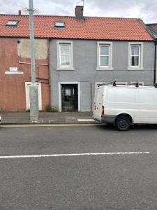 una furgoneta blanca estacionada frente a una casa en 1 bed flat at Drum Street en Edimburgo