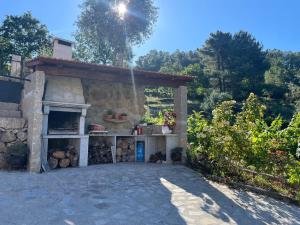 a stone building with a fireplace in a yard at Quintinha de Pinouco in Resende