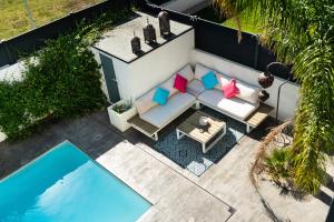 uma vista sobre um pátio com um sofá e uma piscina em SUD VILLA DE LUXE - PLAGES - PISCINE - JACUZZI - Jeux Olympiques 2024 em Lattes